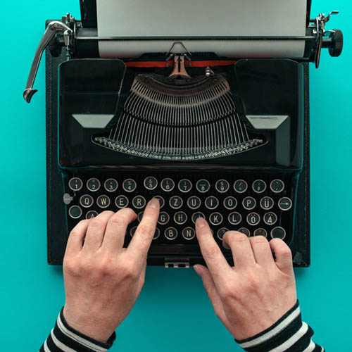 Woman typing vintage typewriter, top view SEO Content Creation